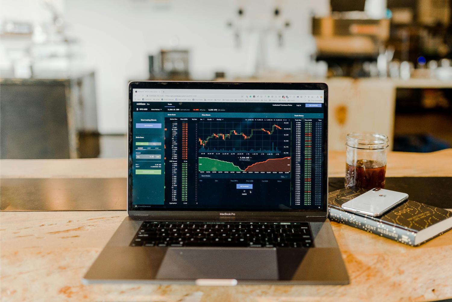 Trading dashboard on laptop with coffee nearby