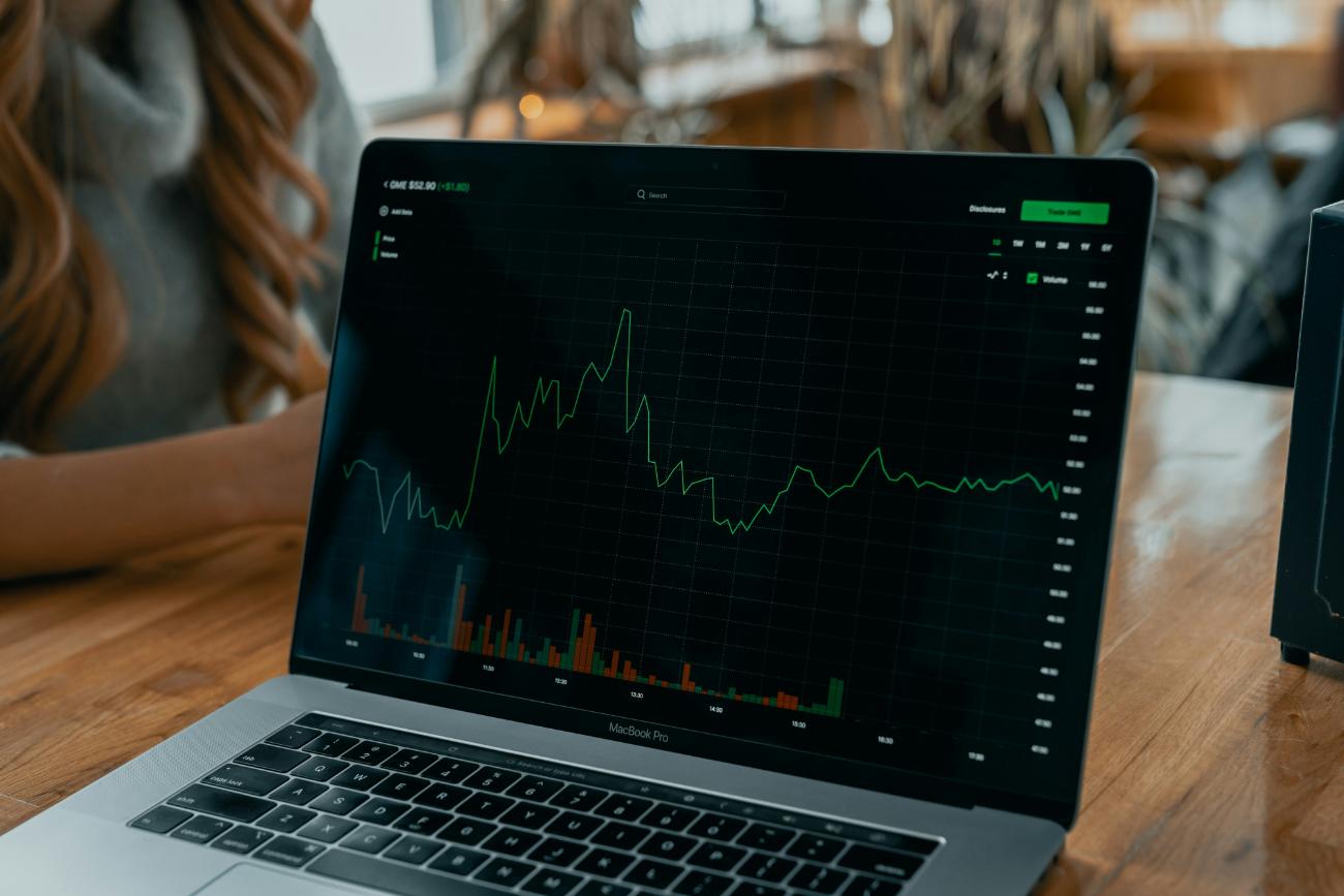 Laptop presenting trading graph with green patterns
